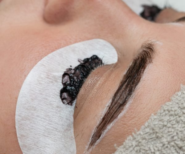 Coloring the eyebrows and eyelashes with henna in a beauty salon, Spa. Professional skincare.